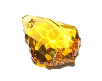 May include: A faceted teardrop-shaped crystal pendant in a golden amber color.