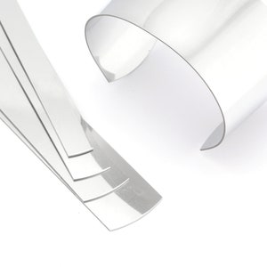 May include: A set of five silver metal strips with rounded edges and a clear plastic strip with a curved shape.