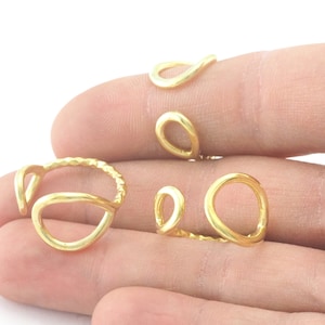 Puede incluir: Conjunto de cuatro anillos de color dorado con diferentes formas y diseños. Los anillos están hechos de metal y tienen un acabado liso y pulido.