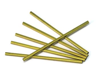 May include: Six gold-colored metal tubes, arranged in a fan shape, with the ends of the tubes visible.
