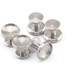 May include: Five silver metal round bezel settings with a raised center post. The bezels are designed to hold small round cabochons or other decorative elements.