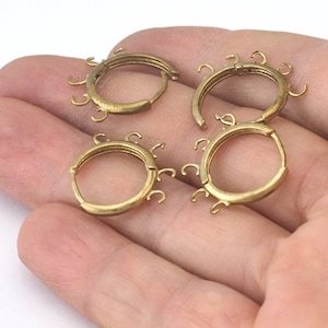 Peut inclure: Quatre boucles d'oreilles créoles dorées avec plusieurs petits crochets attachés à chaque créole.