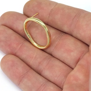 May include: A gold oval-shaped earring with a post.