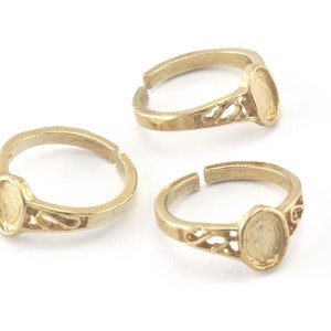 Puede incluir: Tres anillos de tono dorado con un diseño de filigrana y un bisel redondo para engastar una piedra o cabujón.
