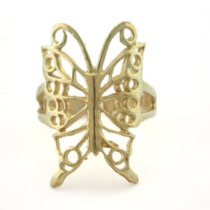 May include: A gold-colored butterfly ring with a delicate, intricate design. The ring is made of metal and has a simple band.