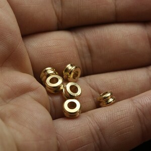 May include: A close-up of six gold-coloured metal rings, likely for jewellery making or crafting.