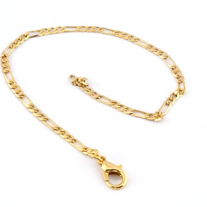 May include: A gold chain necklace with a lobster clasp closure. The chain is made of a flat, oval-shaped link.