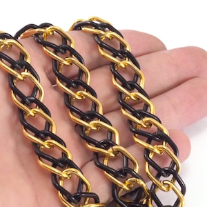 May include: A black and gold chain necklace with a chunky link design. The chain is made of two different colors of metal, black and gold.