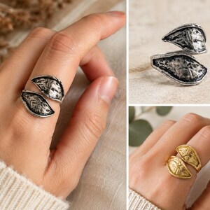 Woman wearing an adjustable antique silver leaf ring on finger, nature inspired botanical statement jewelry.