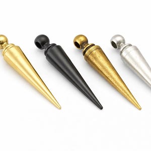 May include: A white ceramic mug with a black handle and the text "But First, Coffee" in a bold, black font. The mug is set against a blurred background, suggesting a cosy setting.