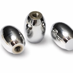 May include: Three shiny, chrome-finished cabinet knobs with a smooth, oval shape. Each knob has a threaded insert for easy installation. The knobs are set against a clean white background, highlighting their reflective surfaces.