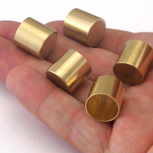 Puede incluir: Cinco tapas cil&iacute;ndricas de metal de color dorado, probablemente para muebles u otros objetos.