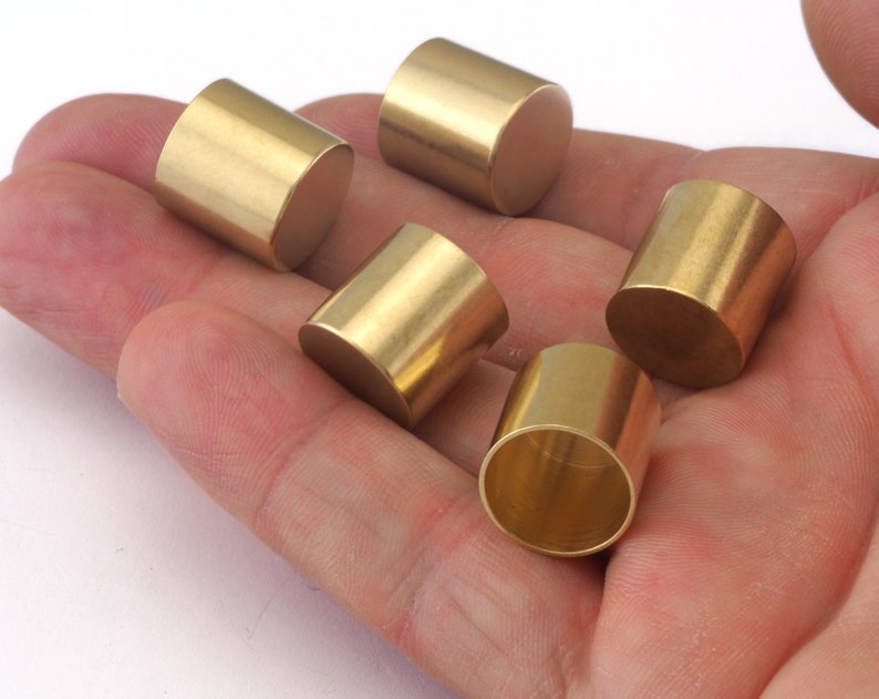 Puede incluir: Cinco tapas cil&iacute;ndricas de metal de color dorado, probablemente para muebles u otros objetos.