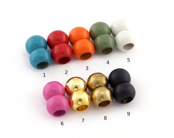 May include: A collection of nine pairs of spherical beads arranged in rows, labeled with numbers 1 through 9. The beads feature various finishes including glossy solid colors like teal, red, orange, olive green, white, pink, and black, alongside metallic gold.