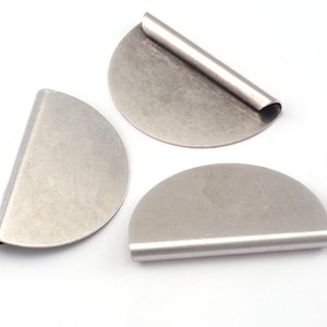 May include: Three silver metal half-circle shapes with a rolled edge. The shapes are slightly different sizes.