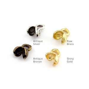 Puede incluir: Cuatro acabados diferentes de terminales de cordón de metal. Plata antigua, bronce antiguo, latón en bruto y oro brillante.