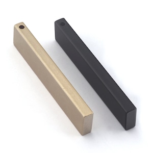 May include: Two rectangular metal bar pulls, one gold and one black. Both have a small hole at the top for mounting.