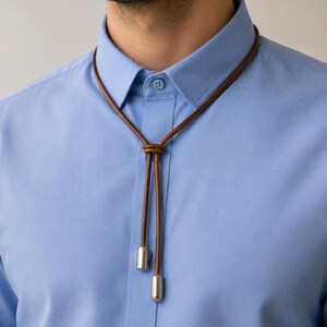 Parliament blue shirt with brown leather bolo style necklace featuring light antique silver cord end caps