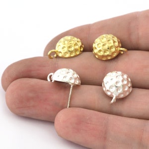 Peut inclure: Quatre breloques en métal en forme de balle de golf, deux dorées et deux argentées. Les breloques ont une surface texturée et une boucle pour les attacher à un collier ou un bracelet.