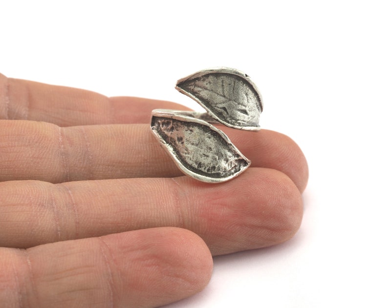 A silver ring with a leaf design. The ring is open and adjustable.