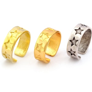 May include: Three ear cuffs with a star design. The ear cuffs are made of metal and come in gold, silver, and antique silver.