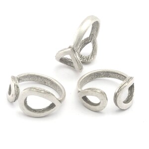May include: Three silver-toned rings with a teardrop design. The rings have an open design with a textured finish. The rings are displayed on a white background.