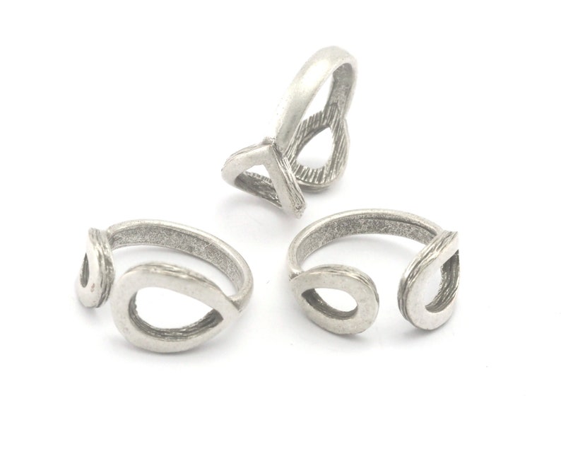 May include: Three silver-toned rings with a teardrop design. The rings have an open design with a textured finish. The rings are displayed on a white background.