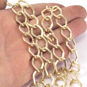 May include: Gold chain with a flat, rectangular link design. The chain is made of metal and has a shiny finish.