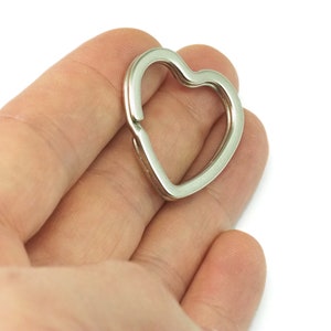 May include: A silver heart-shaped key ring.