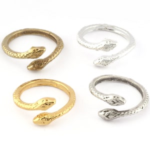 May include: Four snake rings, two gold and two silver, with the snake's head wrapped around the band.