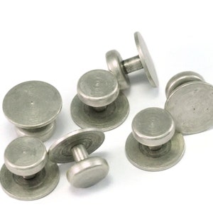 May include: Six silver-toned cufflinks with a circular design. Each cufflink has a raised center and a smooth, slightly textured surface.