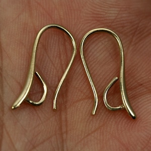 May include: Two gold-toned earring hooks, each with a curved wire and a small loop at the end.