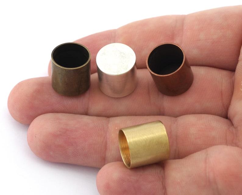 Puede incluir: Cuatro tapas met&aacute;licas de diferentes colores: lat&oacute;n, plata, cobre y oro. Las tapas son cil&iacute;ndricas y tienen un acabado liso.