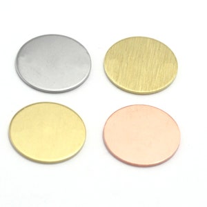 Può includere: Quattro dischi rotondi in metallo di diversi colori: argento, oro, ottone e rame. I dischi sono lisci e hanno una superficie leggermente testurizzata.