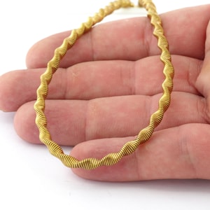 Op de afbeelding: Een gouden ketting met een gedraaid, touwachtig ontwerp.