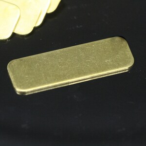 May include: A rectangular brass name tag with a brushed finish.