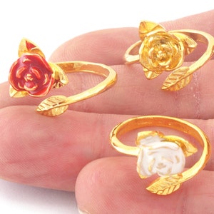 May include: Three adjustable gold-tone rings featuring a rose design. The roses are red, yellow and white.