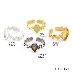 May include: Four adjustable rings with a 6x8mm blank teardrop-shaped bezel set in a leaf design. The rings are shown in shiny silver, antique silver, raw brass, and shiny gold.