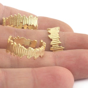 May include: Three gold-toned adjustable rings with a textured, wavy design.