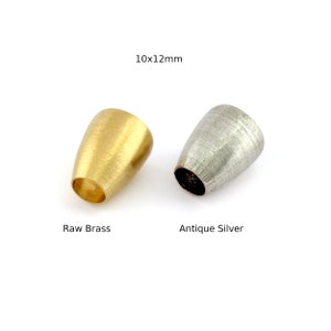 May include: Two metal end caps, one in raw brass and one in antique silver, measuring 10x12mm.  The caps are cone-shaped with a smooth, brushed finish.