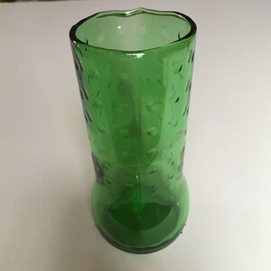 May include: A green glass vase with a textured surface. The vase is made from a recycled glass bottle.