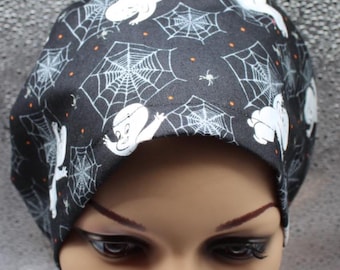 Peut inclure: Casquette noire sur le thème d'Halloween avec un motif répété de fantômes de dessins animés blancs, de toiles d'araignées et de points orange. La casquette est faite d'un tissu foncé et est conçue pour être portée sur la tête.