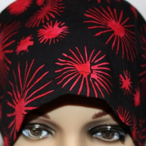 May include: Black scrub hat with a red firework print.