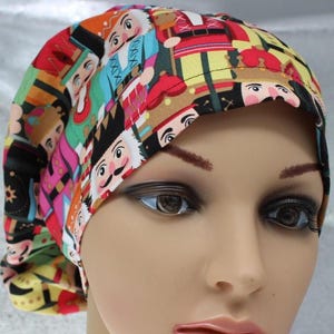 May include: A colorful scrub cap featuring a repeating pattern of nutcracker figures in various colors. The cap has a rounded shape and is made of a lightweight fabric. The design includes red, blue, yellow, and black elements.