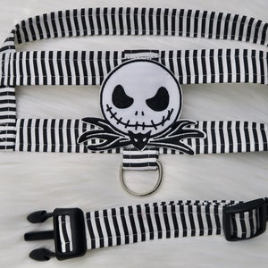 May include: Black and white striped dog harness with a black and white Jack Skellington character patch.