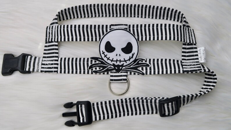 May include: Black and white striped dog harness with a black and white Jack Skellington character patch.