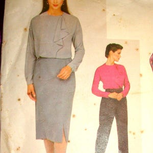 May include: Vintage Vogue American Designer sewing pattern featuring Anne Klein designs. The pattern includes illustrations of a skirt suit, a top and pants ensemble, and a floral jumpsuit. The pattern number is 2370.