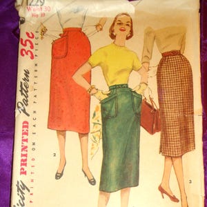 May include: Vintage Simplicity printed pattern featuring illustrations of women's skirts. The pattern cover displays three skirt designs in various colors, including red, green, and plaid. The text on the cover reads "Simplicity Printed Pattern" and "Simple to Make."