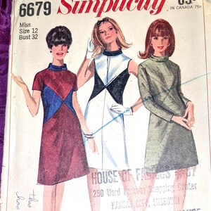 May include: A vintage Simplicity sewing pattern envelope 6679 for a miss size 12, bust 32. The cover features illustrations of three dresses: a maroon and blue short-sleeve dress, a white and black sleeveless dress, and a solid olive green long-sleeve dress.