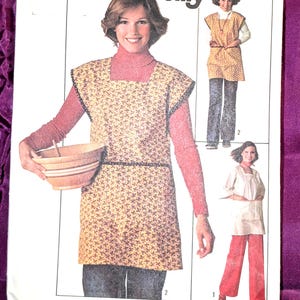 May include: A Simplicity 7708 Jiffy sewing pattern envelope for a small size 8-10 miss. The cover features illustrations of a sleeveless tunic or apron with a small floral print, shown worn over long-sleeved tops and pants in various color combinations.